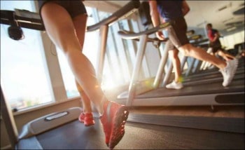 a woman's feet running on a treadmill